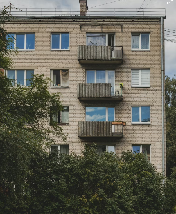 Aged cream-brick Eastern-European apartment building before renovation
